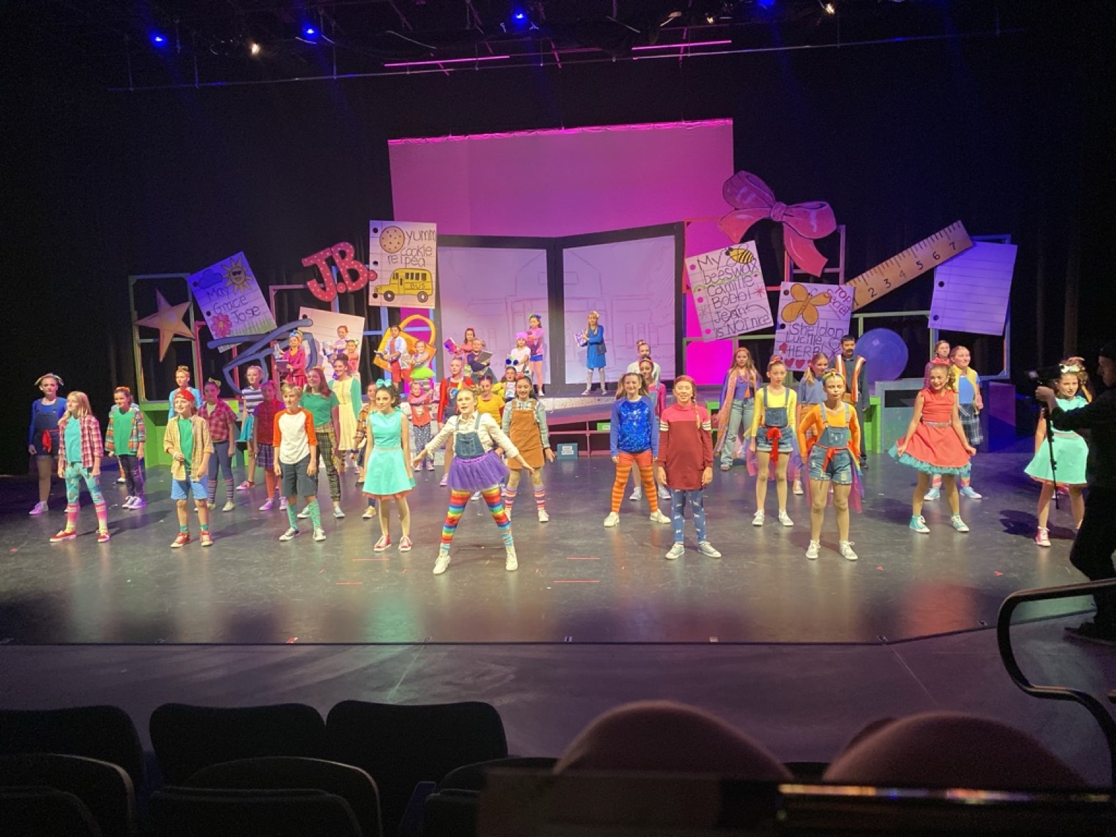 The full cast of Junie B. Jones performing on a colorful school-themed set