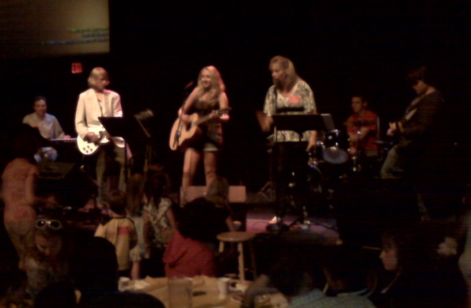 Taylor Fox singing and playing guitar live with a band